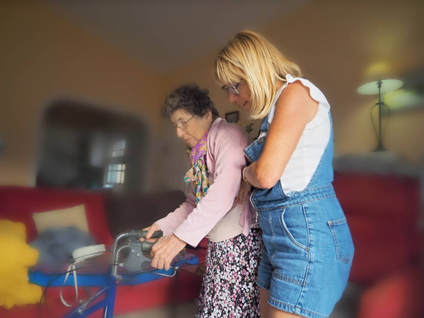 Altenpflegerin führt Seniorin mit Gehwagen, - Foto, Bild