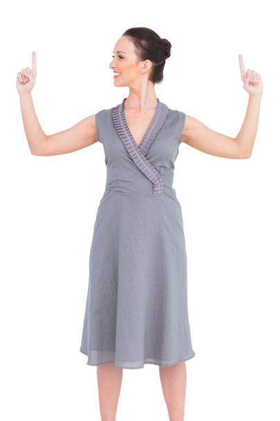 Cheerful elegant woman in classy dress pointing fingers up - Φωτογραφία, εικόνα