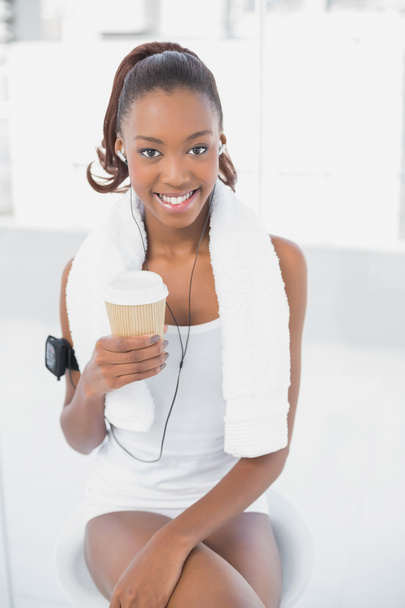 Relaxed athletic woman listening to music holding coffee - Fotoğraf, Görsel