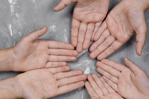 children's hands together in a circle on gray background, top view.  - Foto, Imagem