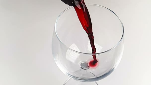 nalévání červeného vína do nápojového skla na bílém pozadí, koncept nutriční zdravotní péče, pomalá střelba - Záběry, video