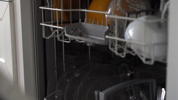 жінка відкриває посудомийну машину і кладе в неї брудну тарілку
 - Кадри, відео