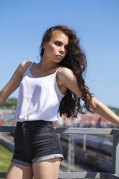Pretty young brunette model in white summer blouse and jeans, su - Foto, afbeelding