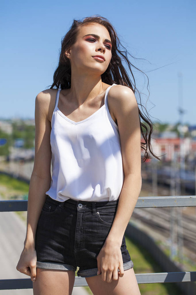 Pretty young brunette model in white summer blouse and jeans, su - Fotoğraf, Görsel