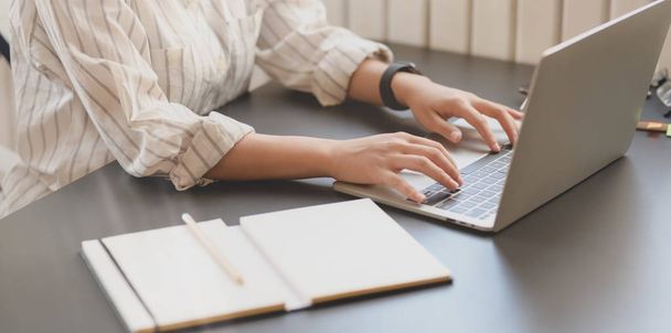 Крупним планом молода красива бізнес-леді, що друкує на ноутбуці на зручному робочому місці
  - Фото, зображення