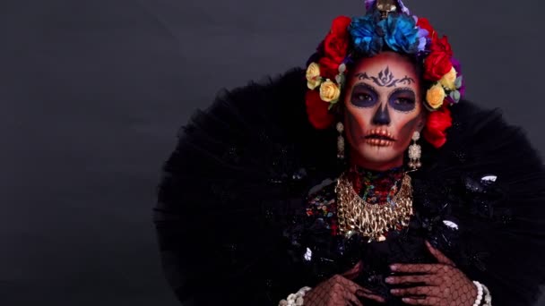 Close-up portret van een vrouw met een suikerschedel make-up gekleed met bloemkroon. Halloween concept - Video