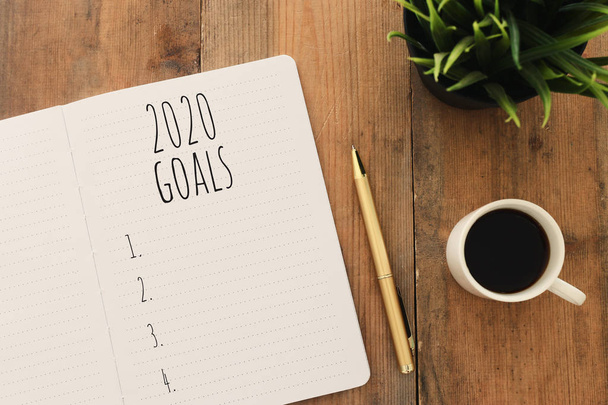 Business concept of top view 2020 goals list with notebook, cup of coffee over wooden desk - Foto, Bild