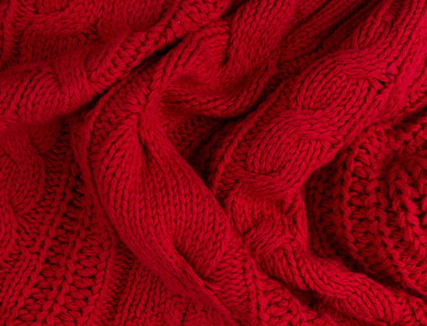 Textuur van rood gebreide stof close-up. Breiwerk van wol - Foto, afbeelding