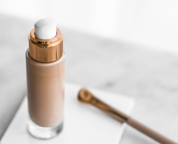 Make-up foundation fles en contouren borstel op marmer, make-up - Foto, afbeelding