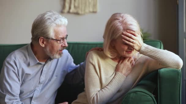 Desperate elderly wife crying worried husband comforting her - Filmati, video