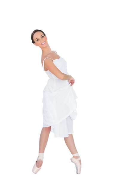 Smiling young ballet dancer standing on her tiptoes - Foto, imagen