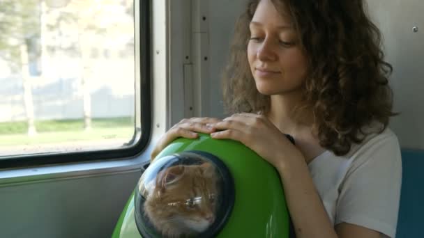 Kız kediyi sırt çantasına koyup trenle seyahat ediyor. - Video, Çekim