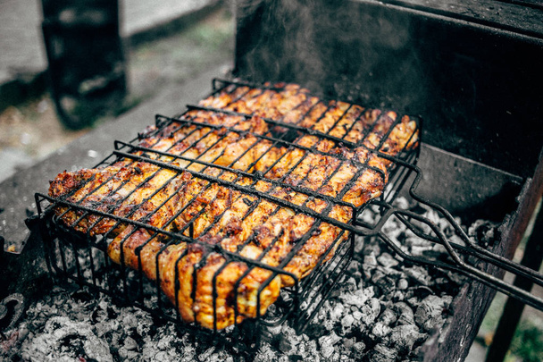 Grilled marinated chicken on a metal grid - Photo, Image
