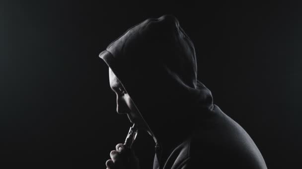 Video muže s elektronickou cigaretou v kapuci - Záběry, video