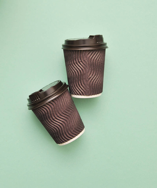 抽象的なカラフルな背景の上の茶色の紙コーヒーカップ. - 写真・画像