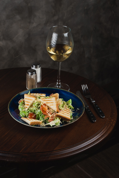 Delicious salad and wine on table - Фото, зображення