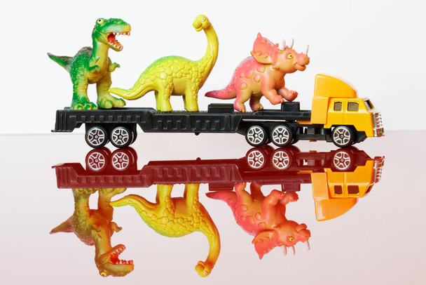 Большой грузовик везет динозавров в заповедник, на ферму или на Т
 - Фото, изображение
