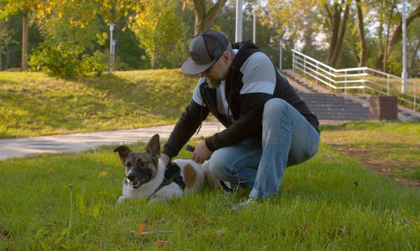 Чоловік середнього віку з собакою в парку
 - Фото, зображення