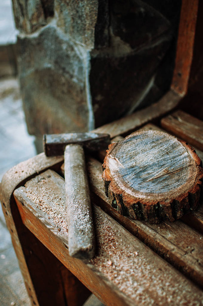 an old vintage hammer and a round bar of pine with sawdust on a bench. A wooden food stand for a master class. DIY concept. - Fotografie, Obrázek