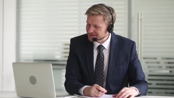 Businessman wearing headset using microphone talking negotiating with company client - Metraje, vídeo