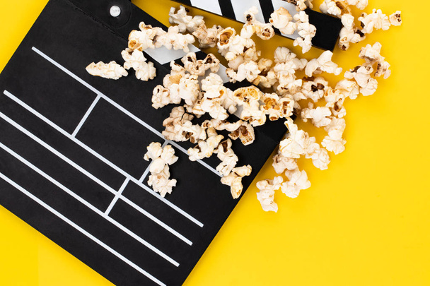 Popcorn and clapperboard on colorful background. Top view. - Photo, Image