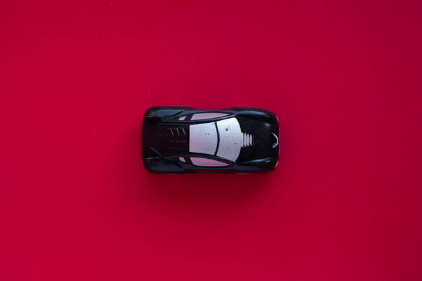 Photo of a toy car on a red background. - Foto, Imagen