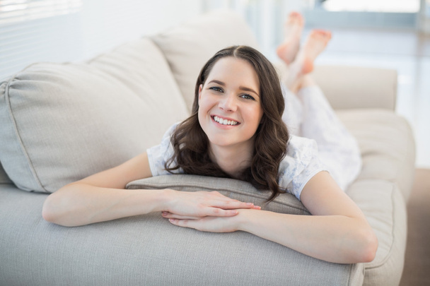 Smiling pretty woman lying on a cosy couch - Fotó, kép