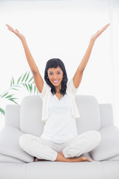 Pleased black haired woman in white clothes raising her arms - Photo, image
