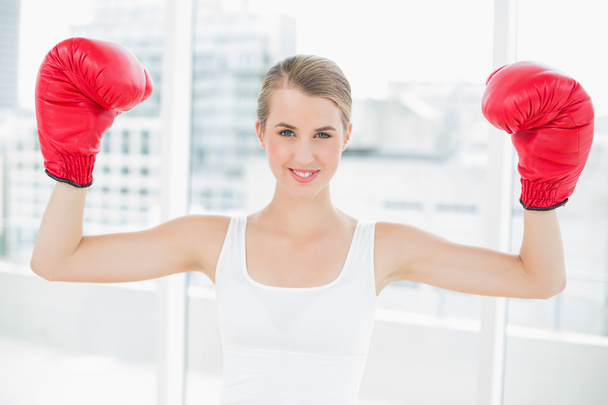 Smiling competitive woman with red boxing gloves cheering up - Fotoğraf, Görsel