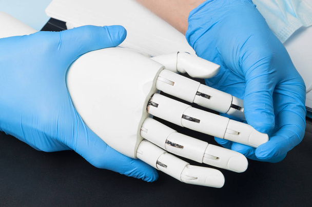 Artificial robotic prosthesis. Doctor holds cyber hand. - Foto, Imagen