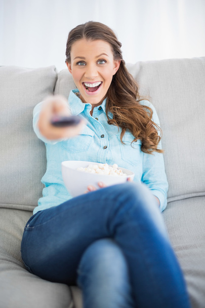 Smiling woman changing tv channel - Фото, изображение