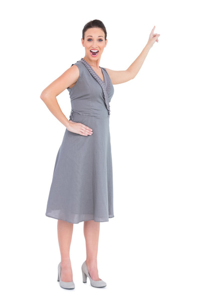 Cheerful gorgeous woman in classy dress indicating direction - Photo, image