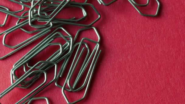 Close-up of Shiny Metal Paper Clips On Red Paper, Zoom Out - Footage, Video