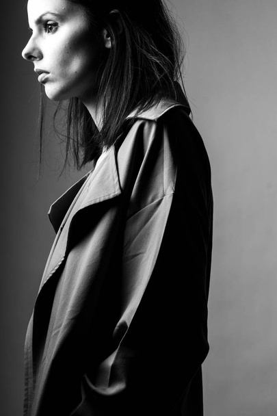 beautiful young girl in a trench coat, black and white  - Photo, Image