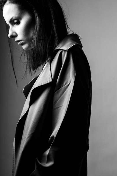 beautiful young girl in a trench coat, black and white  - 写真・画像
