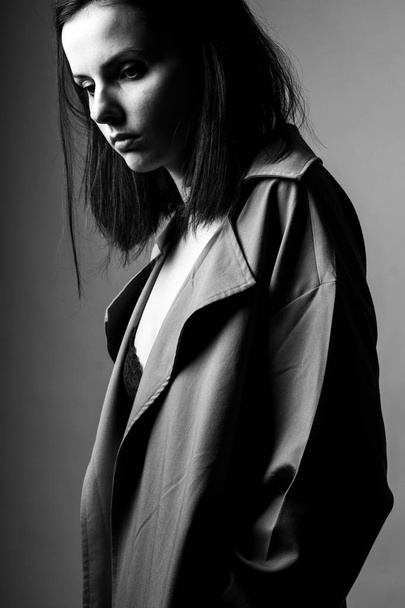 beautiful young girl in a trench coat, black and white  - Valokuva, kuva