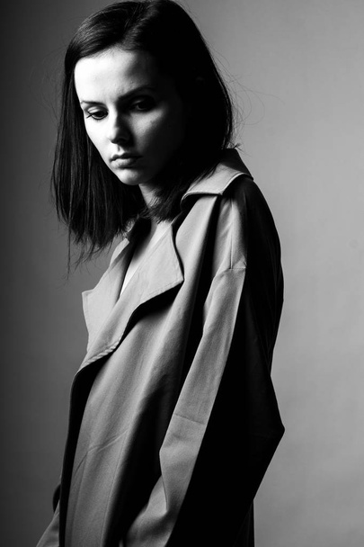 beautiful young girl in a trench coat, black and white  - Valokuva, kuva