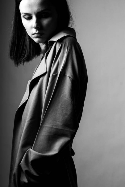 beautiful young girl in a trench coat, black and white  - Fotó, kép