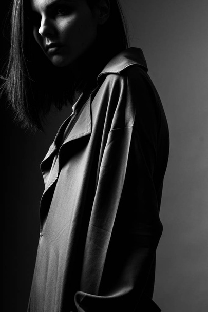 beautiful young girl in a trench coat, black and white  - 写真・画像