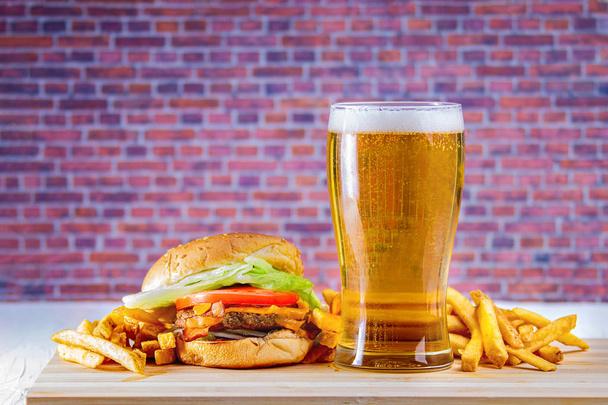 Glass of beer and fries on wooden table - Photo, image