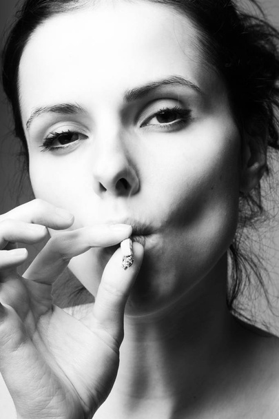 beautiful young girl with a cigarette in her mouth, black and white photo - Foto, Imagem