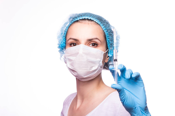 beautiful young girl in medical mask wearing glasses and gloves is holding a syringe - Fotó, kép