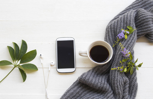 Handy, heißer Kaffee Espresso, Strickwollschal und lila Blume der Lifestylefrau entspannen im Herbst und Winter flache Anordnung auf hölzernem Hintergrund - Foto, Bild