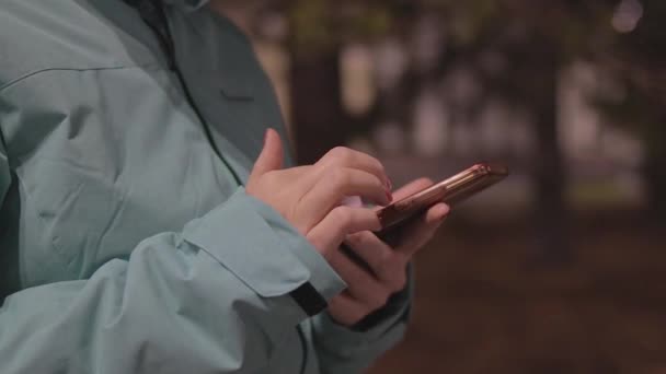 női kéz és okostelefon hideg időben kint este - Felvétel, videó