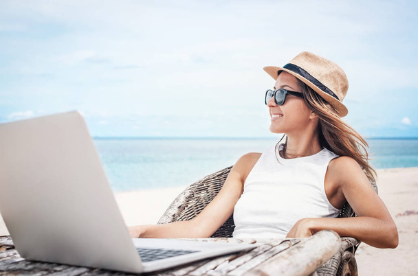 Young woman freelancer working on the beach  - Foto, Bild