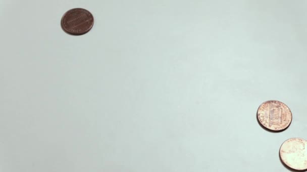 kleine amerikanische Münzen drehen sich auf dem Tisch. das Konzept von Reichtum und Armut, Finanzproblemen und Glücksspiel. Kopierraum. weißer Hintergrund. - Filmmaterial, Video