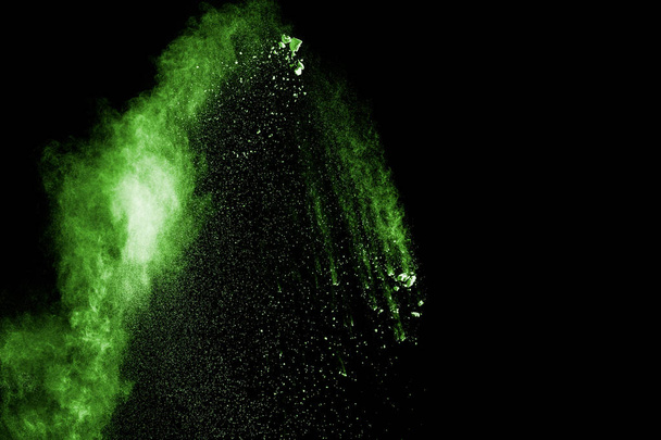 green powder explosion cloud on black background.Freeze motion of green dust particles splash. - Photo, Image