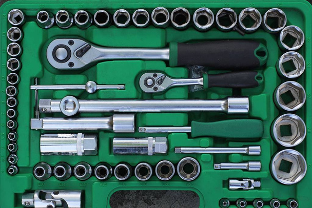 conjunto de herramientas de hierro gris en una caja de plástico abierta verde
 - Foto, Imagen