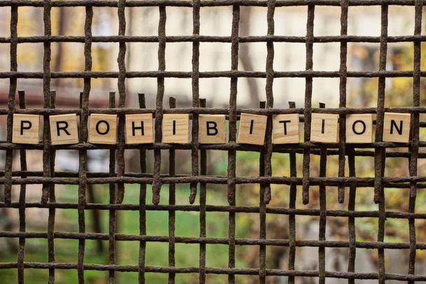 palabra prohibición de letras de madera en una vieja barra de hierro oxidado marrón
 - Foto, Imagen