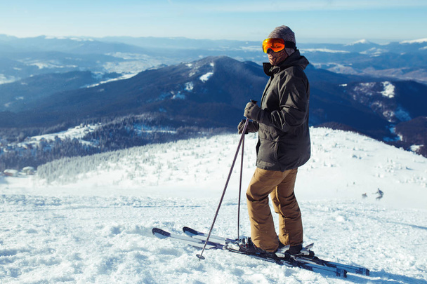 Nice young man skiing in the mountains. Skiing in the snowy mountains, Winter is coming, snowfall. Active lifestyle in winter. Ski resort season is open. Ski equipment, trail. Extreme winter sports. - Zdjęcie, obraz